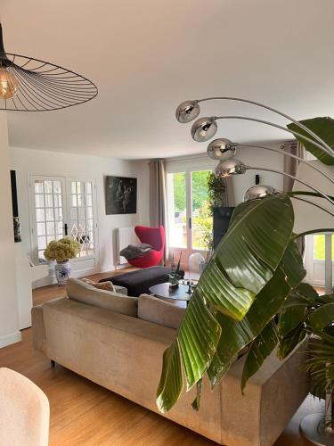 un salon avec un canapé et une plante dans l'établissement Villa proche Paris et Versailles, à Orgeval