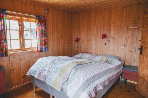 a bedroom with a bed in a wooden wall at Putten Seter in Høvringen