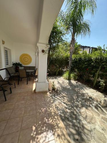 a patio with tables and chairs and a palm tree at Chalet marina studio in Tetouan