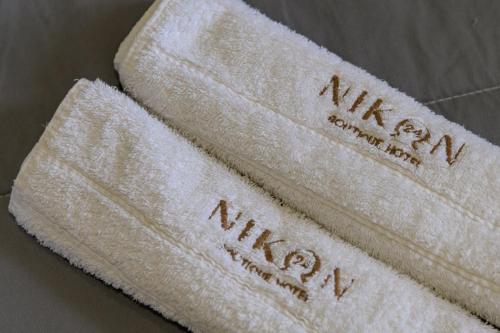two white towels with the words malaysia on them at Nikon Boutique Hotel in Kalamaki