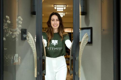 a woman standing in front of a door at Hôtel Artemisia Montmartre in Paris