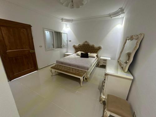 a bedroom with a bed and a mirror and a chair at LEBNA Plage in Nabeul