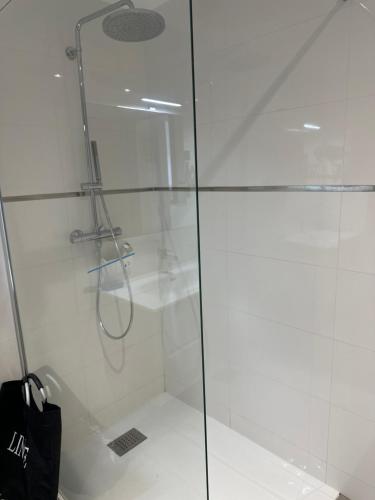 une douche avec une porte vitrée et un sac noir dans l'établissement Domaine d'Arca Eluard 02- PORTO-VECCHIO - Rez de jardin - 2 à 4 pers, à Porto-Vecchio