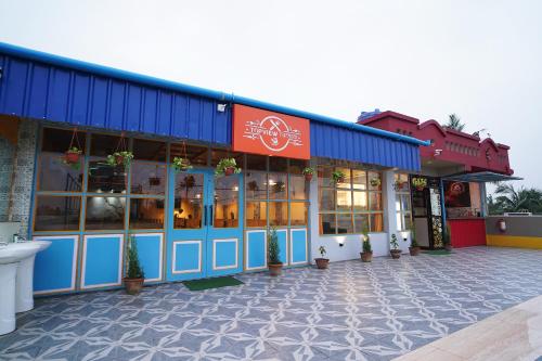 a store front of a restaurant with potted plants at PS Luxury Hotel in Baharampur