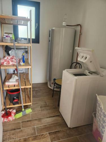 a kitchen with a refrigerator and a floor at Maison plein centre - Piscine in Mimizan