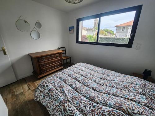 a bedroom with a bed and a window at Maison plein centre - Piscine in Mimizan