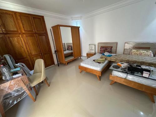 a bedroom with a bed and a desk and a table at LEBNA Plage in Nabeul