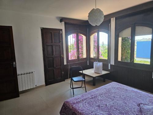 a bedroom with a bed and a table and windows at Villa Del Sol in S'Agaro