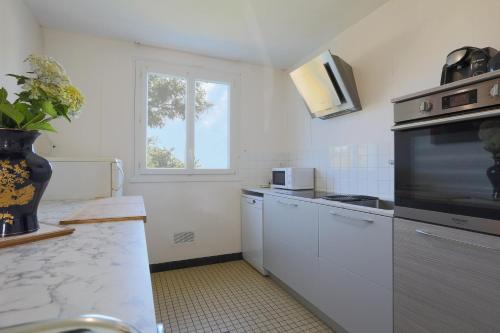 une cuisine avec des appareils électroménagers blancs et une fenêtre dans l'établissement Maison Bretonne, à Ploumagoar