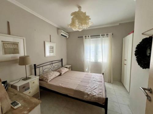 a bedroom with a bed and a chandelier at Villa Terrina in Áyioi Apóstoloi