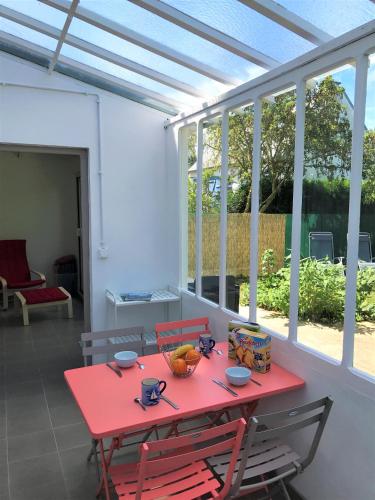 - une table et des chaises rouges dans une chambre avec fenêtres dans l'établissement Gite bord de mer KER GENOVI - BRETAGNE plages et sentier douanier 7mn à pied, à Pléneuf-Val-André
