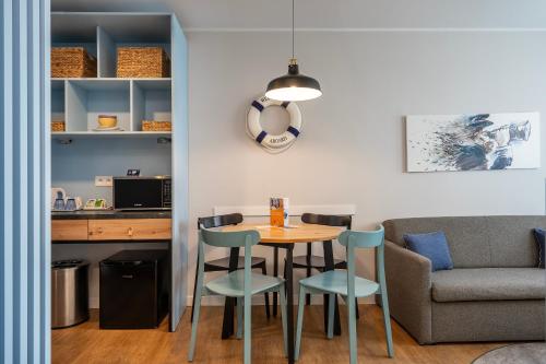 a dining room with a table and chairs and a couch at Halo Hel in Hel