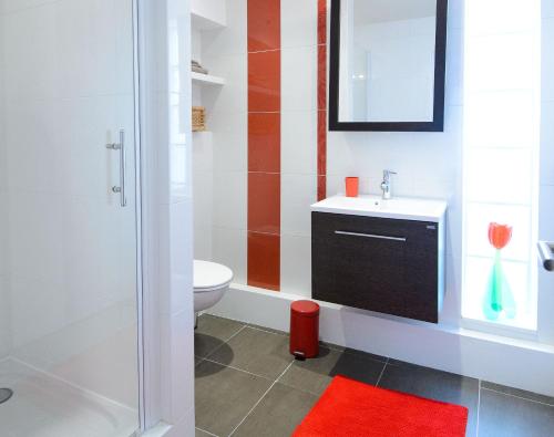 a bathroom with a white toilet and a sink at La Campagne à Paris B&B in Paris