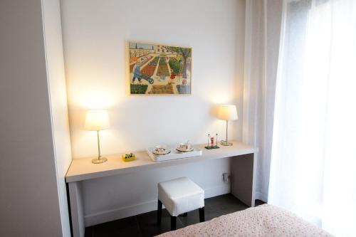 a room with a desk with two lamps and a chair at La Campagne à Paris B&B in Paris