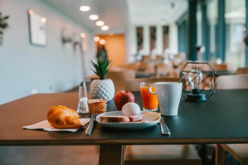 a table with a breakfast of eggs and bread and orange juice at SwissTech Hotel in Lausanne