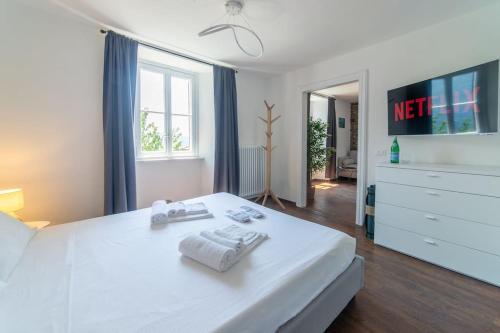 a bedroom with a white bed with two towels on it at Villa amazing lake view with jacuzzi, private garden and gym in Cernobbio