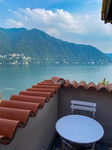 a balcony with a table and a view of the water at Villa amazing lake view with jacuzzi, private garden and gym in Cernobbio