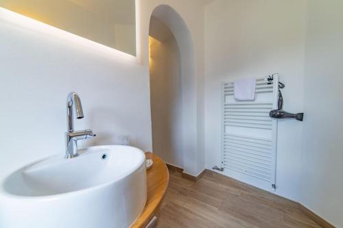 a white bathroom with a sink and a shower at Villa amazing lake view with jacuzzi, private garden and gym in Cernobbio