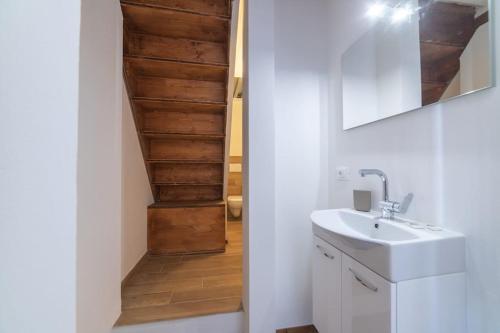 a bathroom with a sink and a wooden stairway at Villa amazing lake view with jacuzzi, private garden and gym in Cernobbio