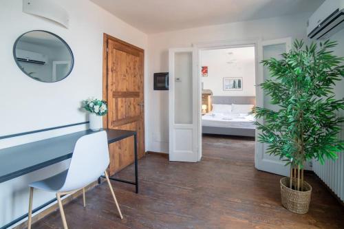 a room with a table and a chair and a bedroom at Villa amazing lake view with jacuzzi, private garden and gym in Cernobbio