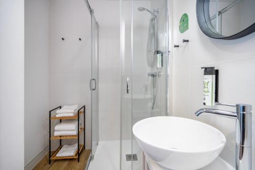 a white bathroom with a sink and a shower at Halo Hel in Hel