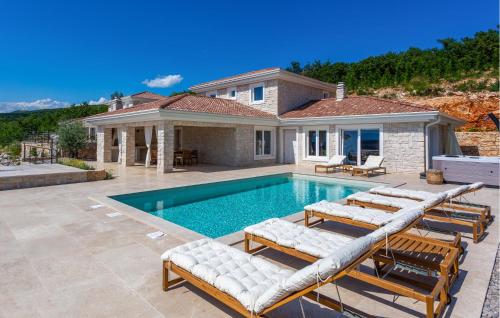 a swimming pool with lounge chairs and a house at Beautiful Home In Jadranovo in Jadranovo