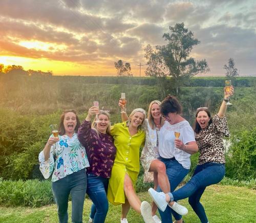 a group of women holding up glasses of wine at Avoca River Cabins in Addo