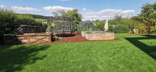 a garden with a greenhouse in a yard at Maison Activhome in Ospern