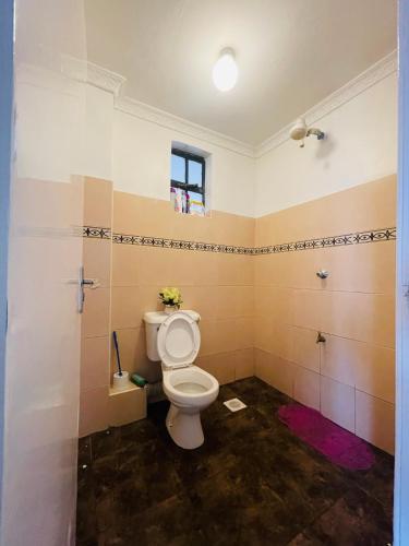 a bathroom with a white toilet in a room at Bella Homes Thika Town in Thika