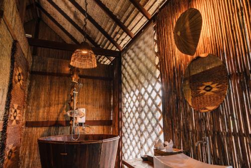a bathroom with a tub in a wooden wall at Thansur Tatai Eco Resort in Tatai