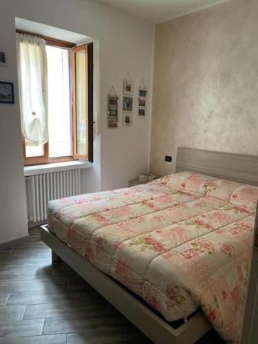 a bedroom with a bed and a window at Casa Argegno in Argegno