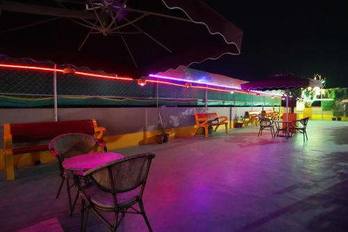 a group of chairs and tables on a patio at night at PS Luxury Hotel in Baharampur