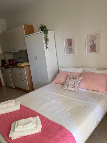 a bedroom with a bed with pink and white sheets at Chili Seaside 2 in Nea Chili