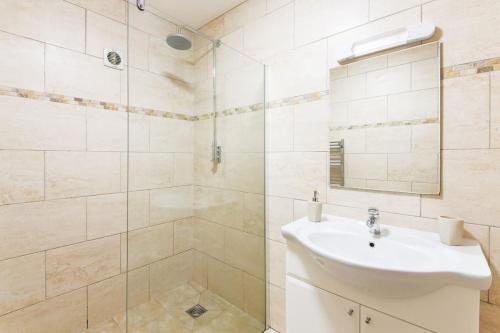 Un baño blanco con lavabo y ducha. en Wheel House @ Goonwinnow Farm, en Newquay
