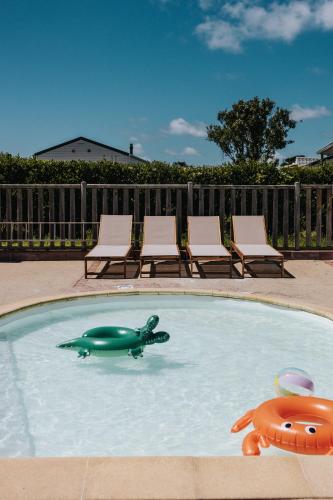 une piscine avec une tortue verte et deux chaises dans l'établissement Camping Liberté Landrellec, à Pleumeur-Bodou