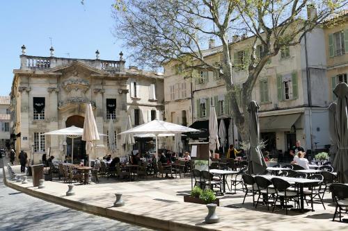 a courtyard with tables and chairs and a building at Le Petit Avignon - chambres & appartement à deux pas du Pont d'Avignon et du Palais des Papes in Avignon