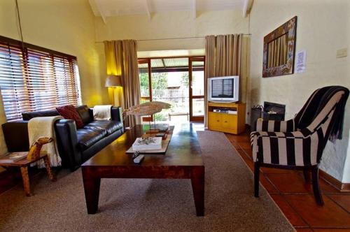 a living room with a couch and a coffee table at Delagoa Cottage Dullstroom in Dullstroom