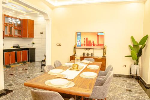 a dining room with a wooden table and chairs at Résidence La Perle - Yaoundé in Yaoundé