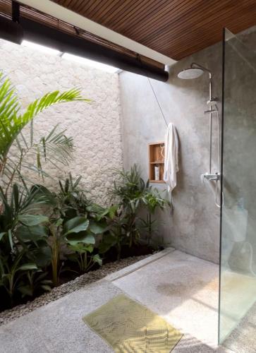 a bathroom with a shower and some plants at Villa Eukene - One Bedroom Private Villa in Kuta Lombok