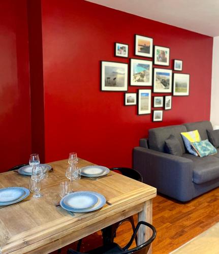a dining room with a table and a red wall at Auron - 4 personnes - Hypercentre in Bourges