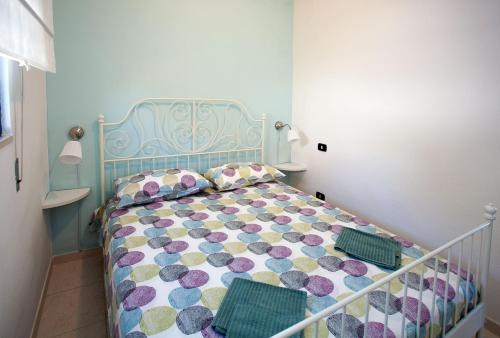 1 dormitorio con 1 cama con edredón azul y morado en Villaggio Ruta, en Taranto