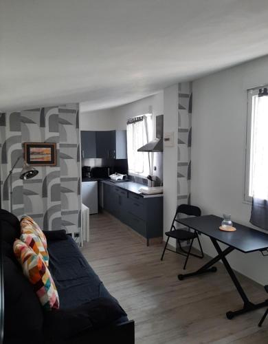 un salon avec un canapé et une cuisine dans l'établissement Studio de la crevette, à Saint-Hilaire-Petitville