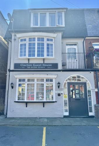 a white building with a sign on the front of it at Clacton Guest House in Clacton-on-Sea