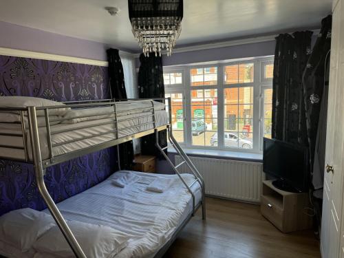 a bedroom with a bunk bed and a tv at Clacton Guest House in Clacton-on-Sea