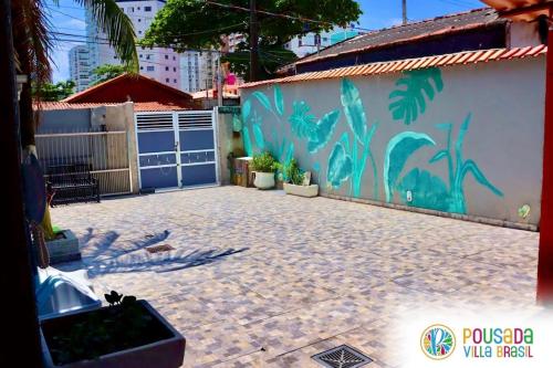 a wall with a mural on the side of a building at Pousada Villa Brasil Ocian in Praia Grande
