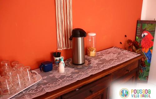 a table with a coffee maker on top of it at Pousada Villa Brasil Ocian in Praia Grande