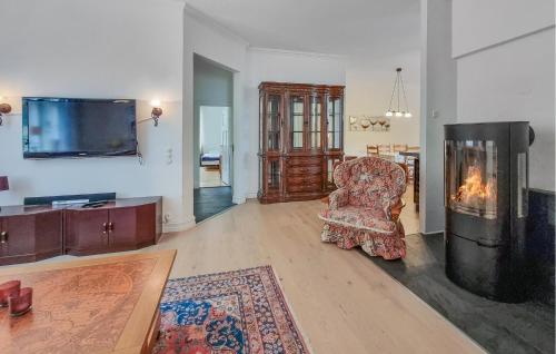 a living room with a chair and a fireplace at Cozy Apartment In Alingsås in Alingsås