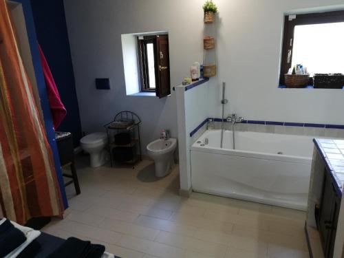 ein Badezimmer mit Badewanne, Toilette und Waschbecken in der Unterkunft Scacciapensieri's home in Trecastagni