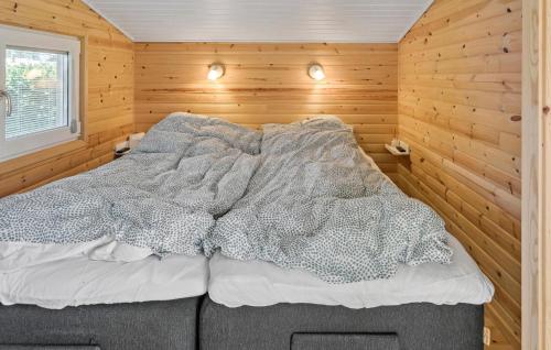 a bedroom with a bed in a wooden wall at Amazing Home In Væggerløse With Wifi in Marielyst
