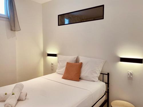 sypialnia z białym łóżkiem z lustrem na ścianie w obiekcie "Garenne 2" Cosy 3 pièces quartier haut climatisé avec patio ! w mieście Sète